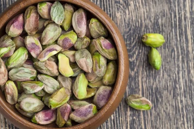 a bowl of unshelled pistachio nuts