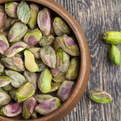 a bowl of unshelled pistachio nuts
